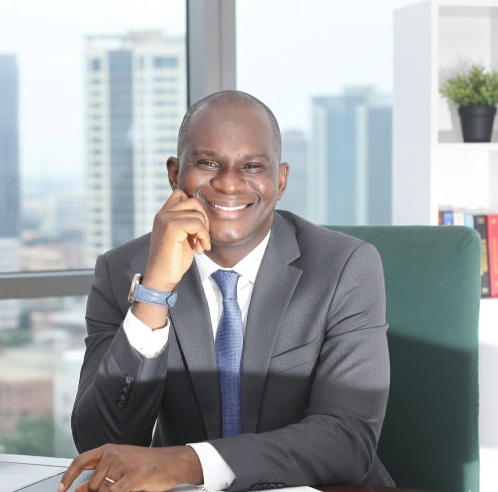 A. T. Adenekan smiling at his desk